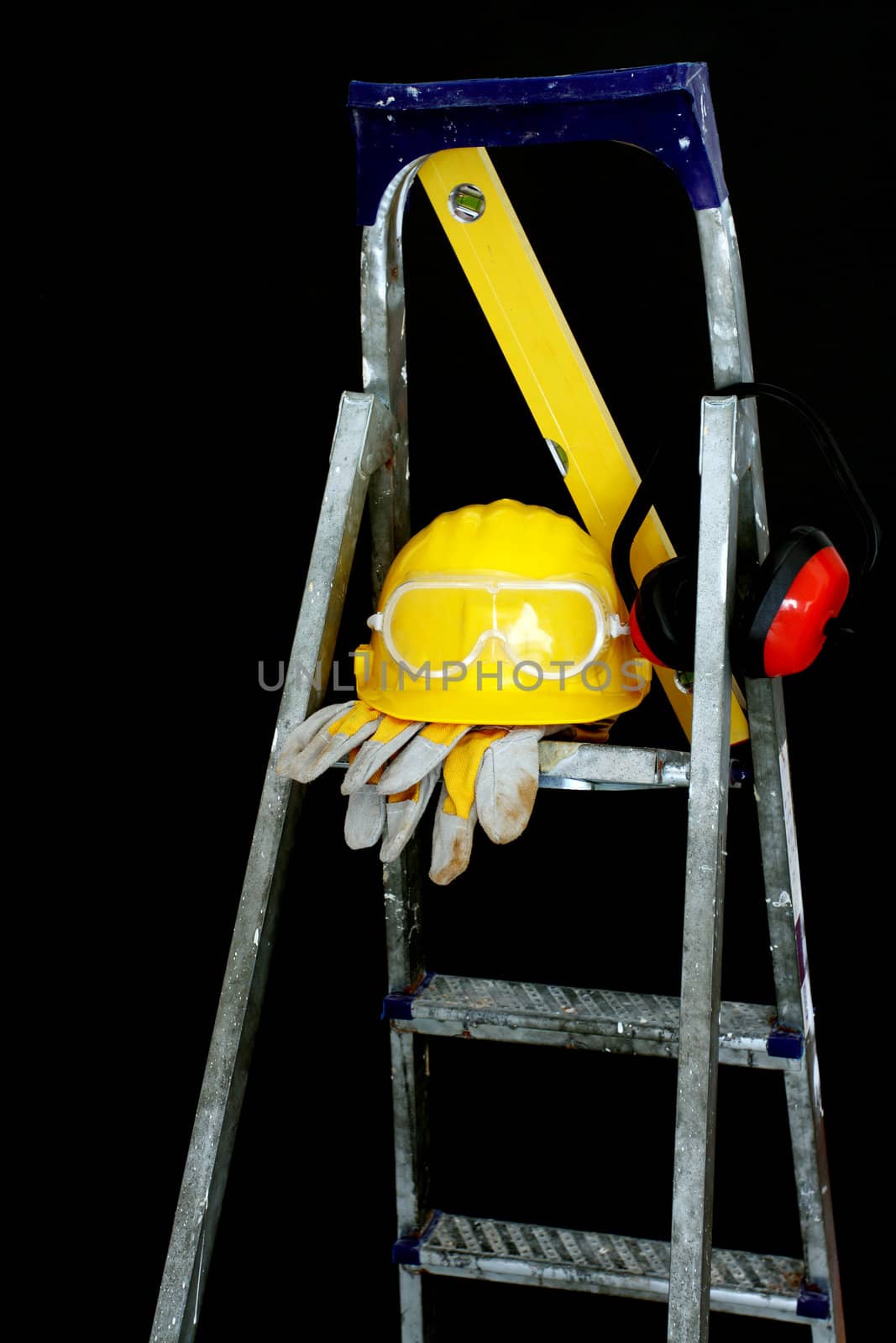 Safety gear kit on step ladder over black