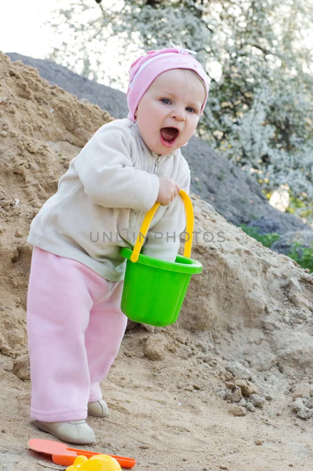 Baby girl having fun playing in sand