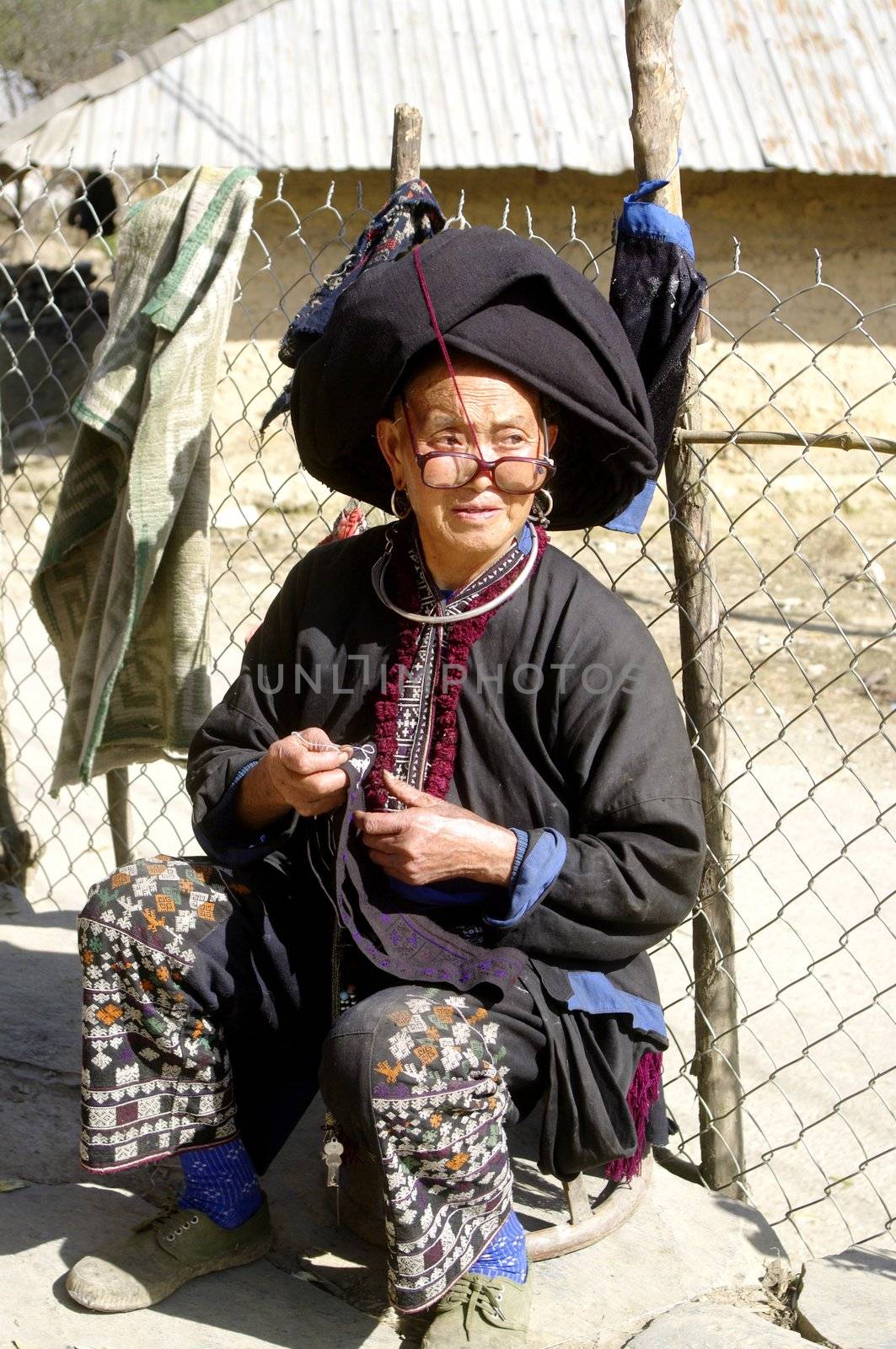 Grandmother Dao ethnic black sewing. The Dao black living in northern Vietnam.Ils are easily remarkable because women wearing embroidered black pants and their typical cap made of a large black turban over their long hair coiled