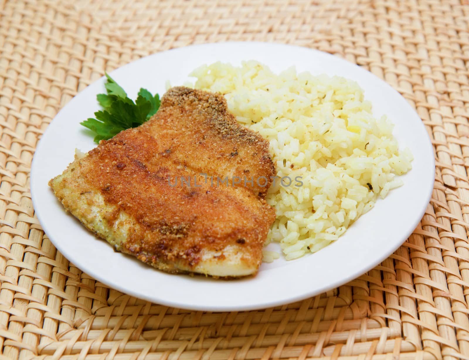 fried breaded tilapia served with rice and herbs
