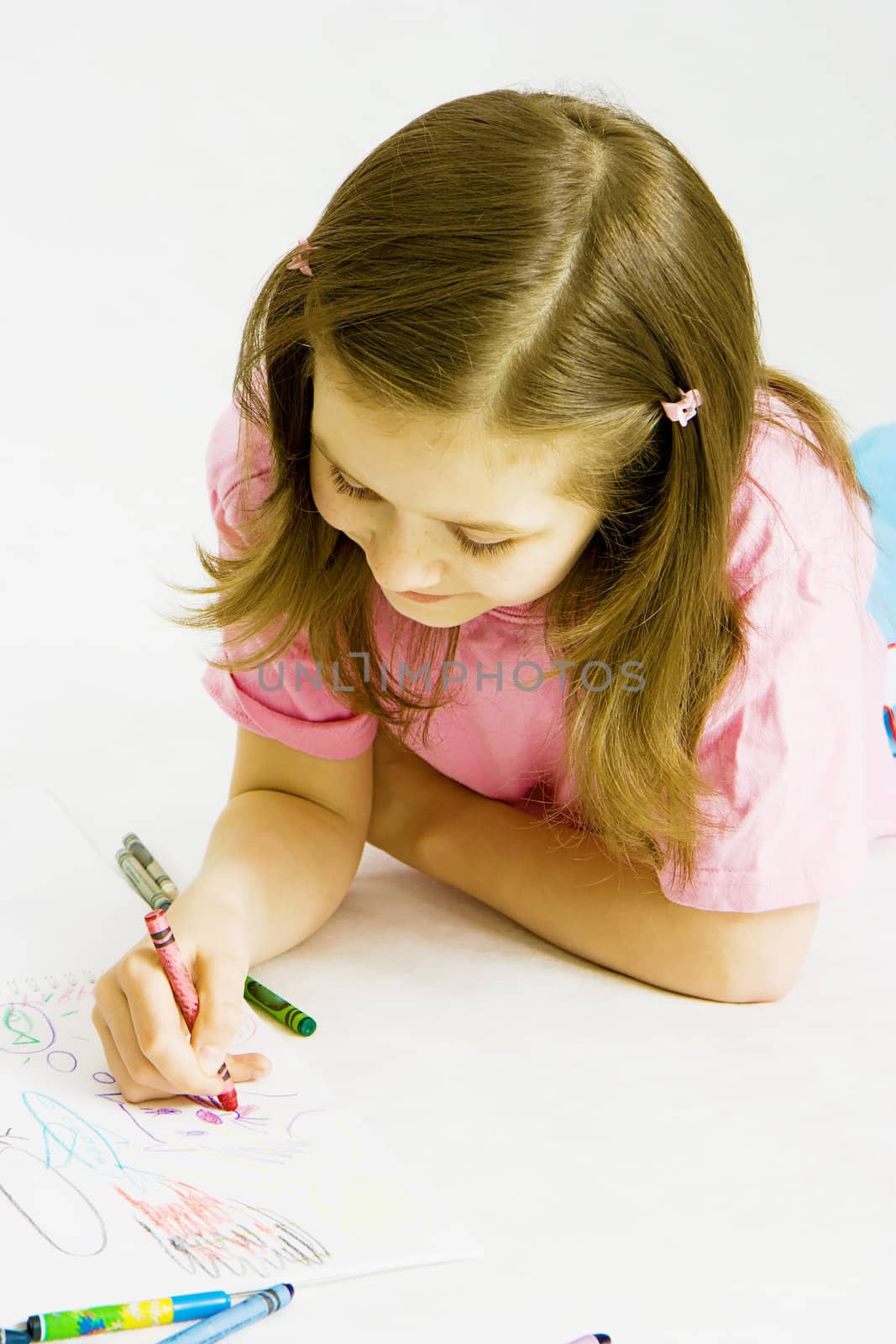 happy girl draws with crayons in the album