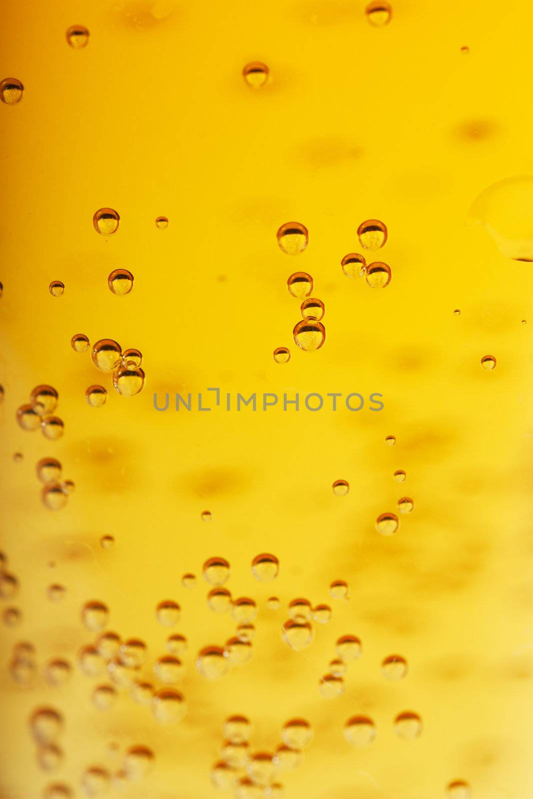 Orange beer with bubbles background. Closeup view.