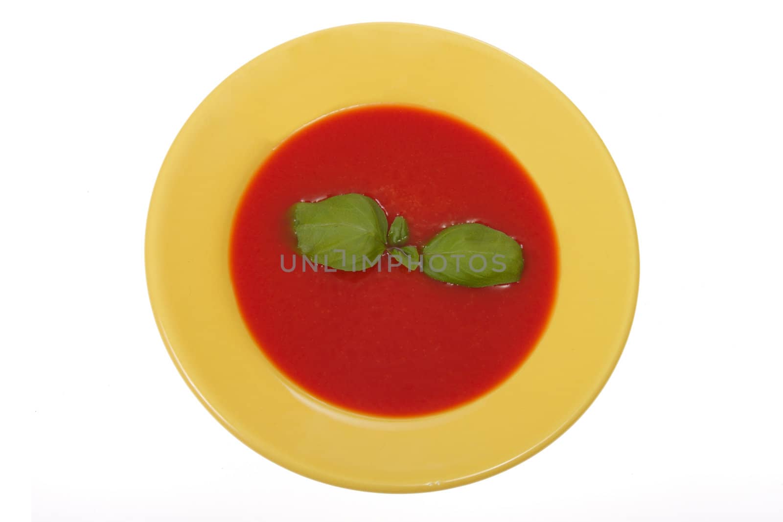 tomato soup in yellow plate, photo on white