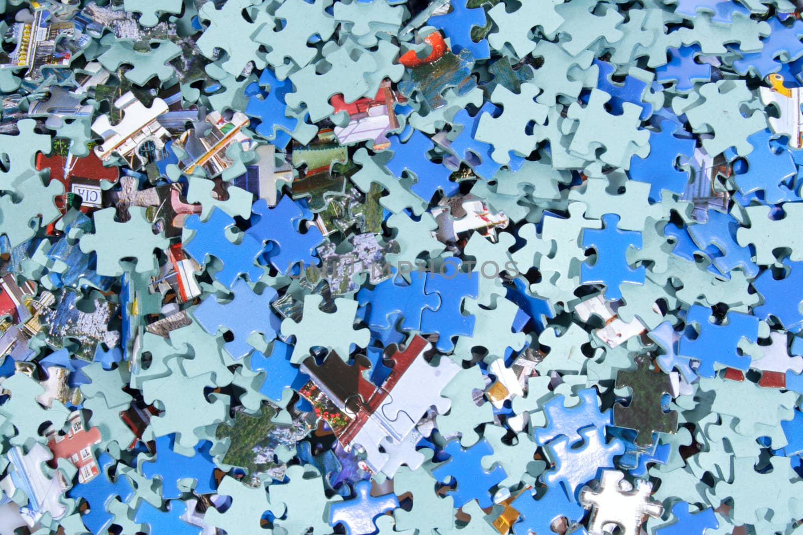 Pieces of puzzle spilled on table, abstract background
