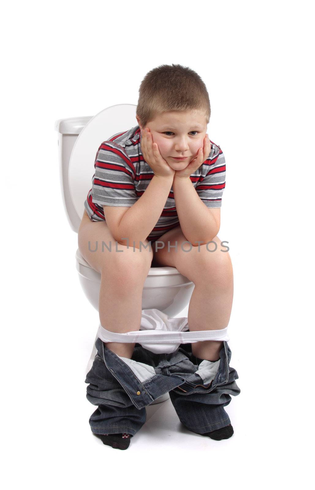 Little boy is sitting on the toilet 