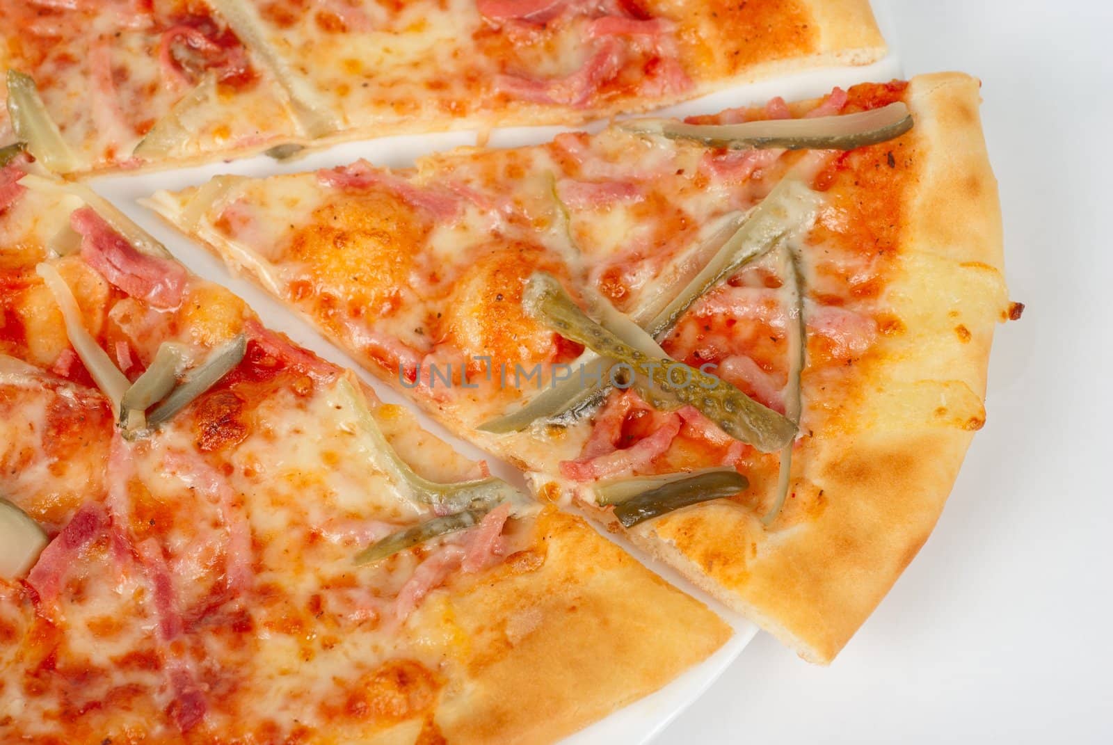 pizza closeup with boiled sausage, ham, marinated gherkin and mozzarella cheese