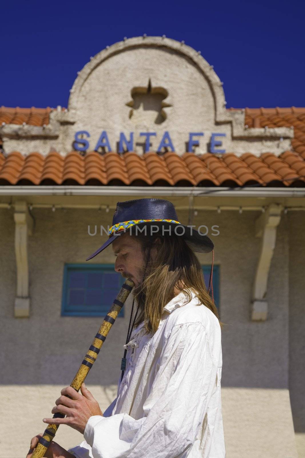 STREET MUSICIAN PLAYING A FLUTE AT SANTA FE NEW MEXICO TRAIN STATION