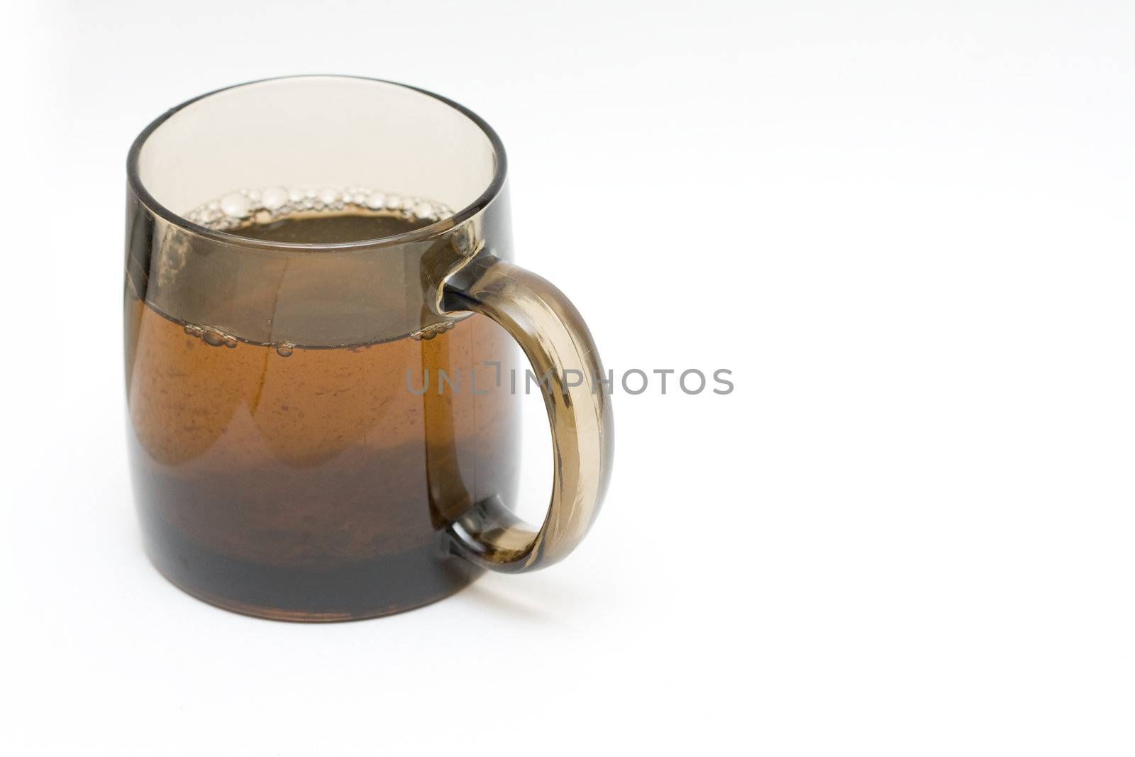 a transparent black cup with tea and tealeafs