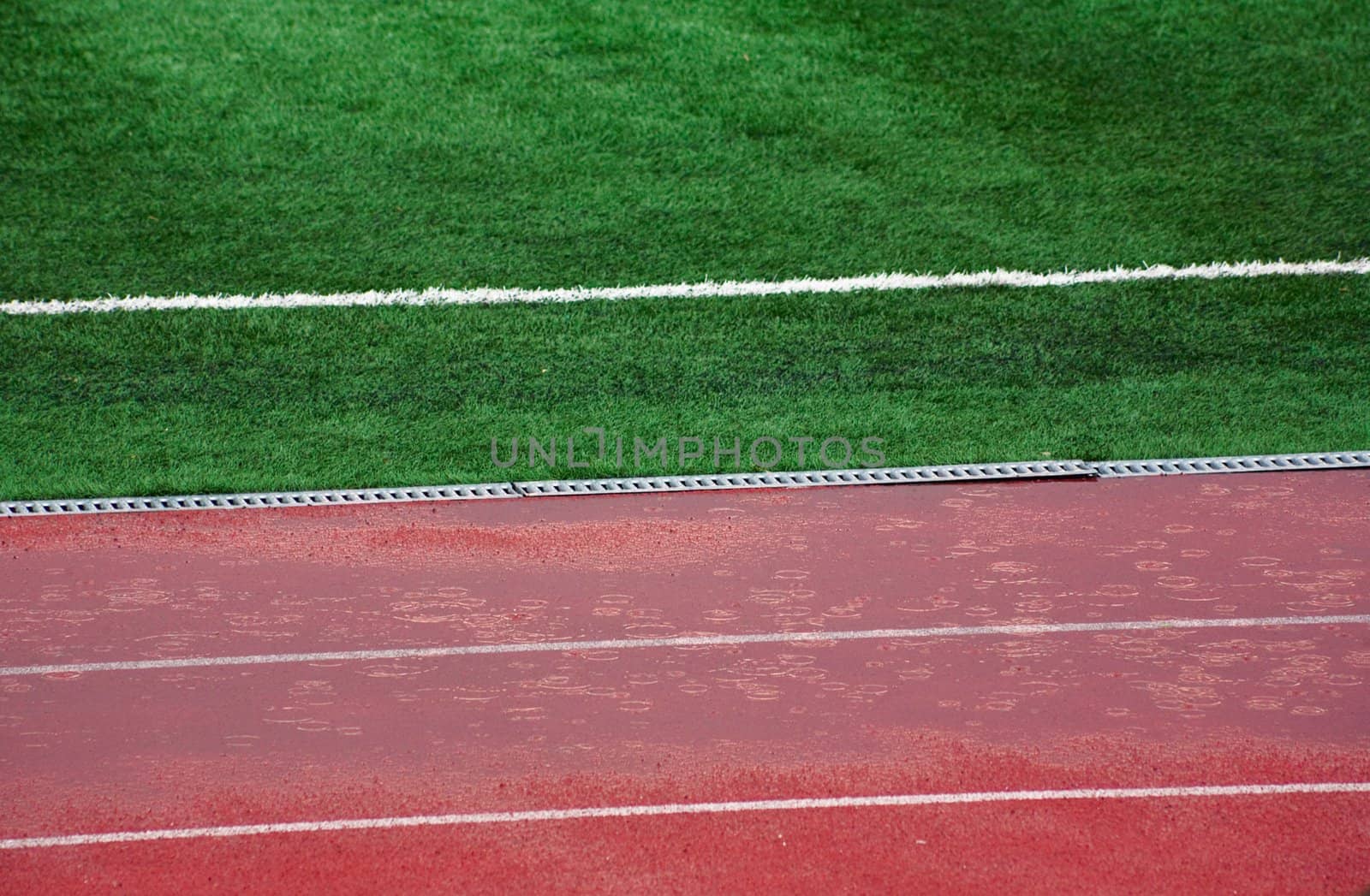 Rain before match Marsielle vs Legia. Wet field and athletic track.