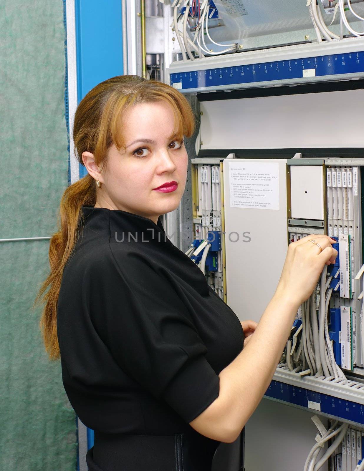 woman engineer serves equipment on digital telephony station 