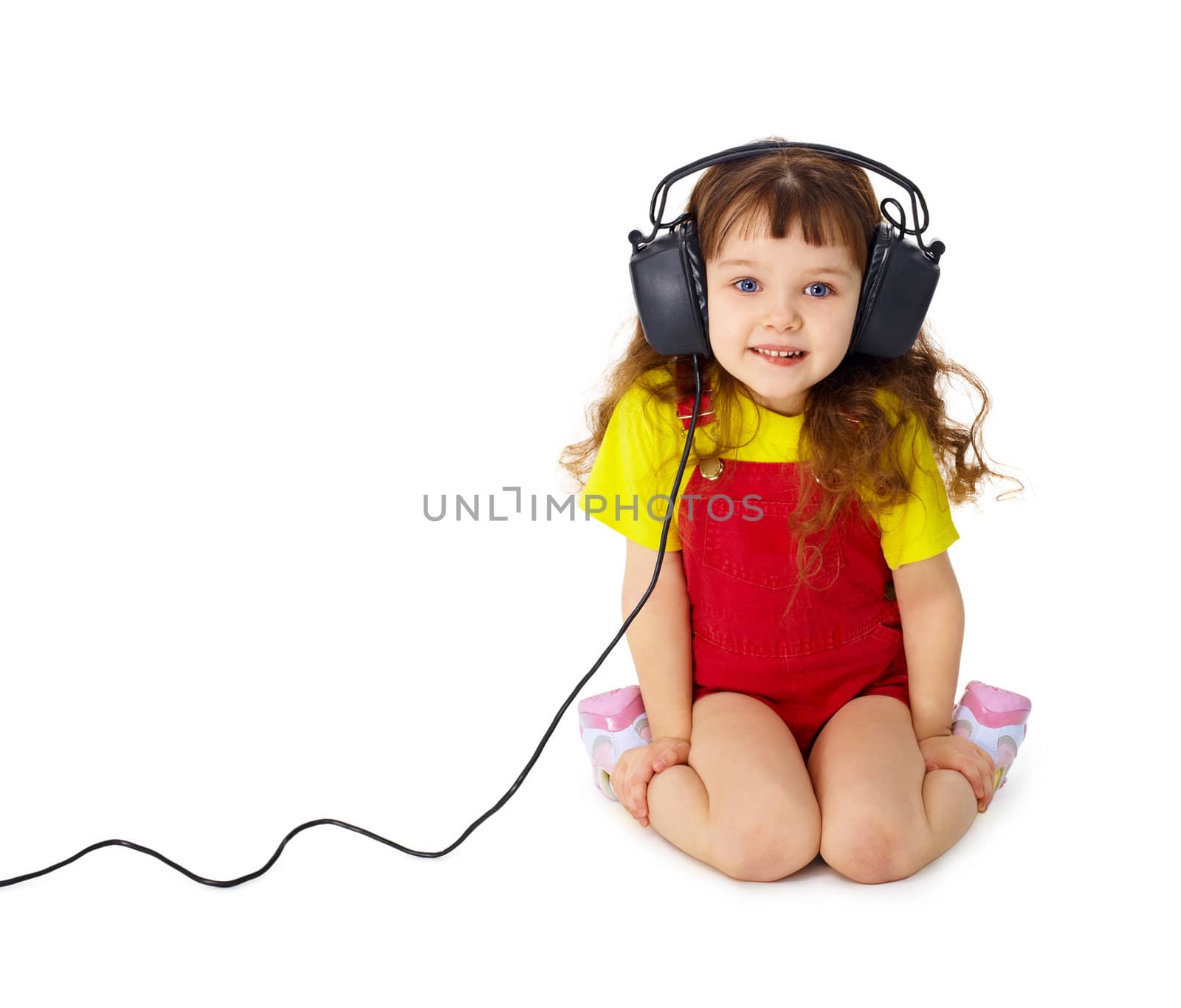 The child sits and listens attentively to the music isolated on white background