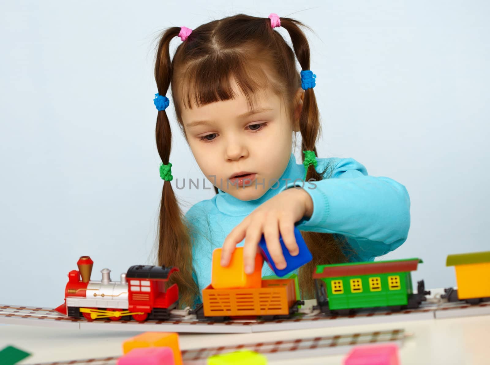 Little girl preschooler playing with toy railway by pzaxe
