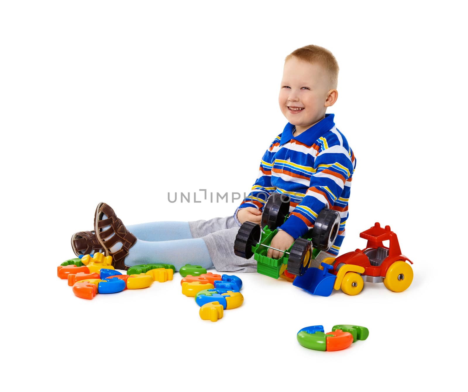 Little boy sitting among toys on floor by pzaxe