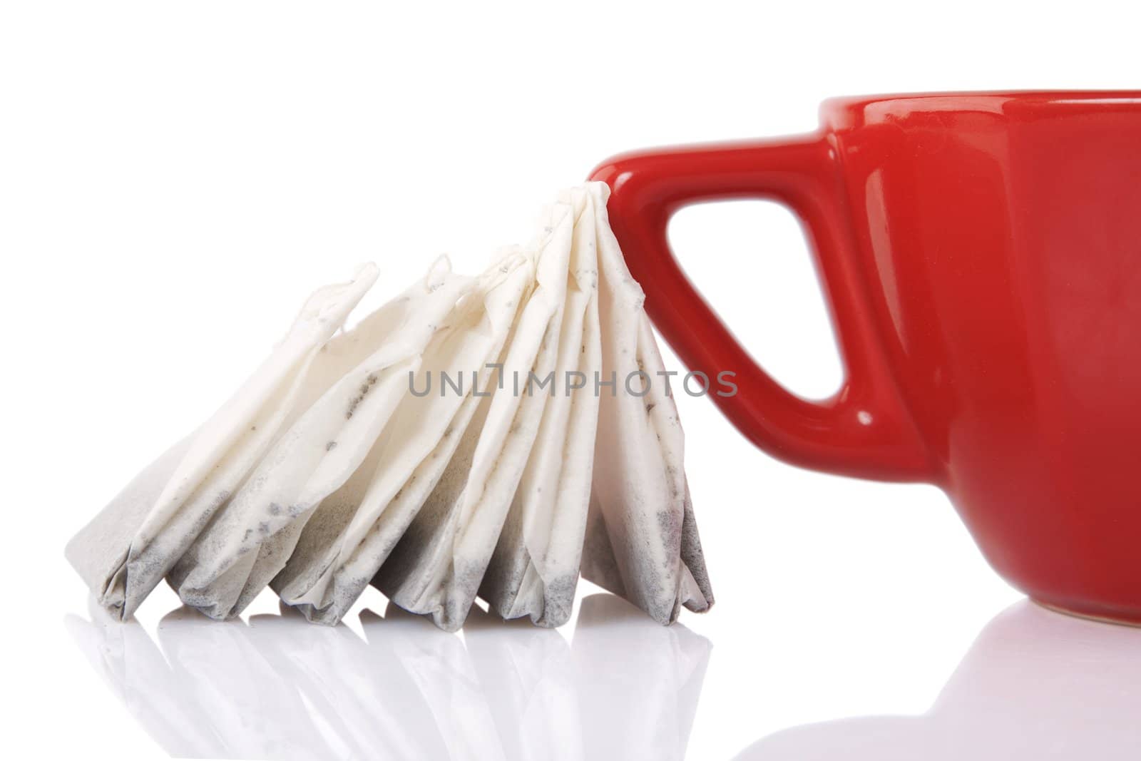 reflection of Red Ceramic cup with tea bags on white background