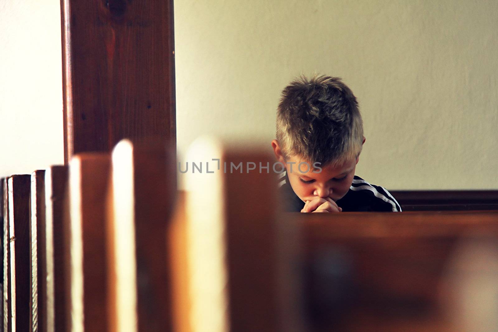 the little boy is praying in the church