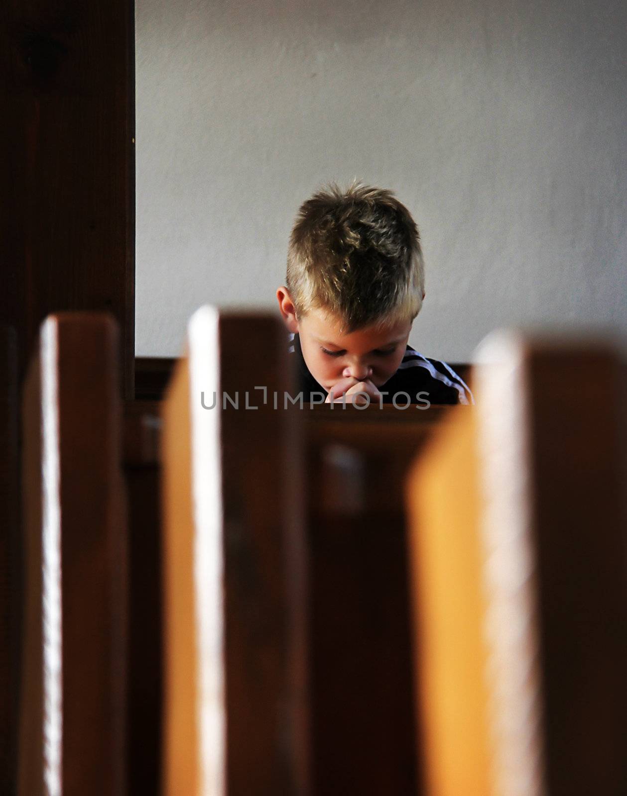 the little boy is praying in the church