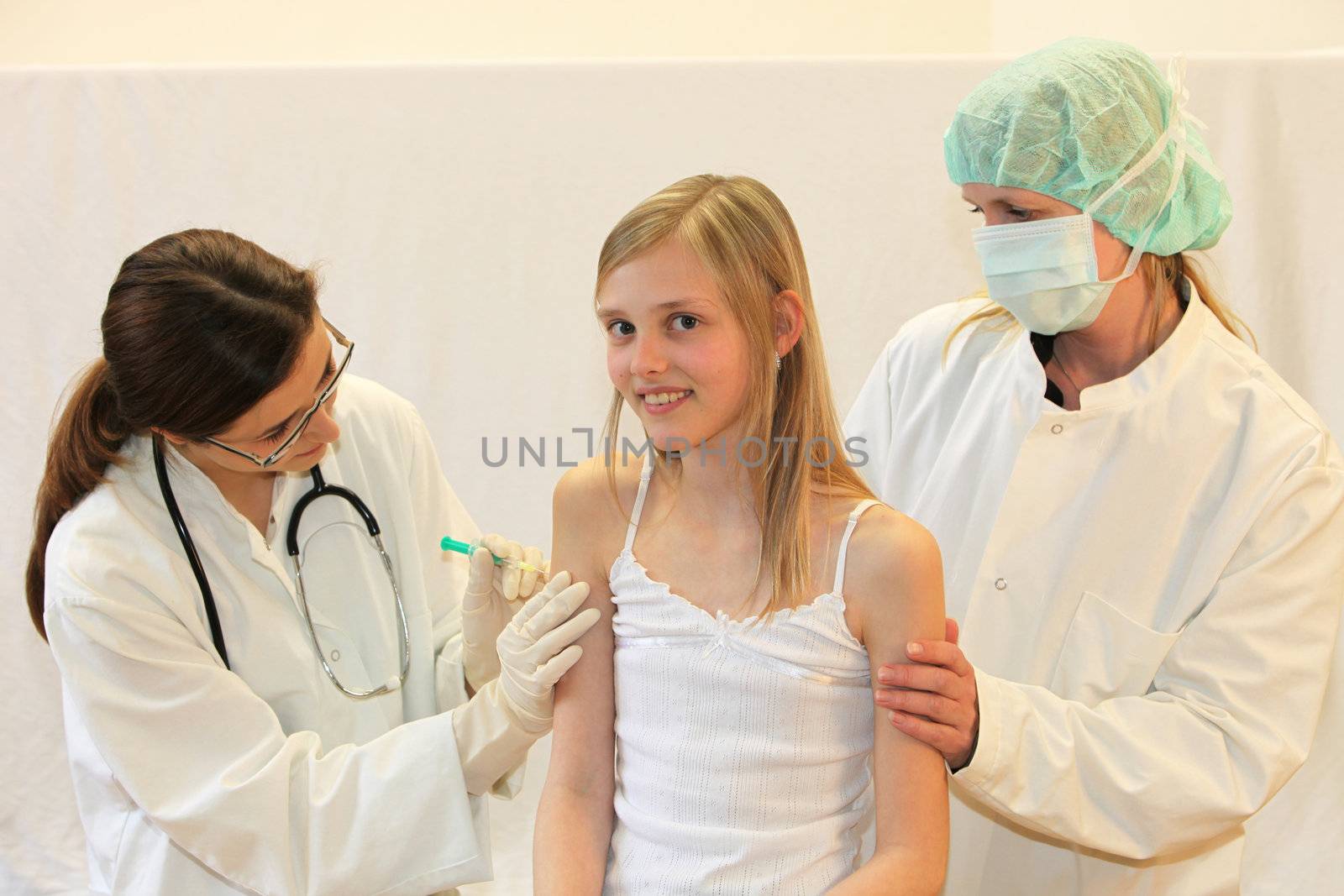 Child the vaccination or injection by a doctor. A nurse with mask helps.