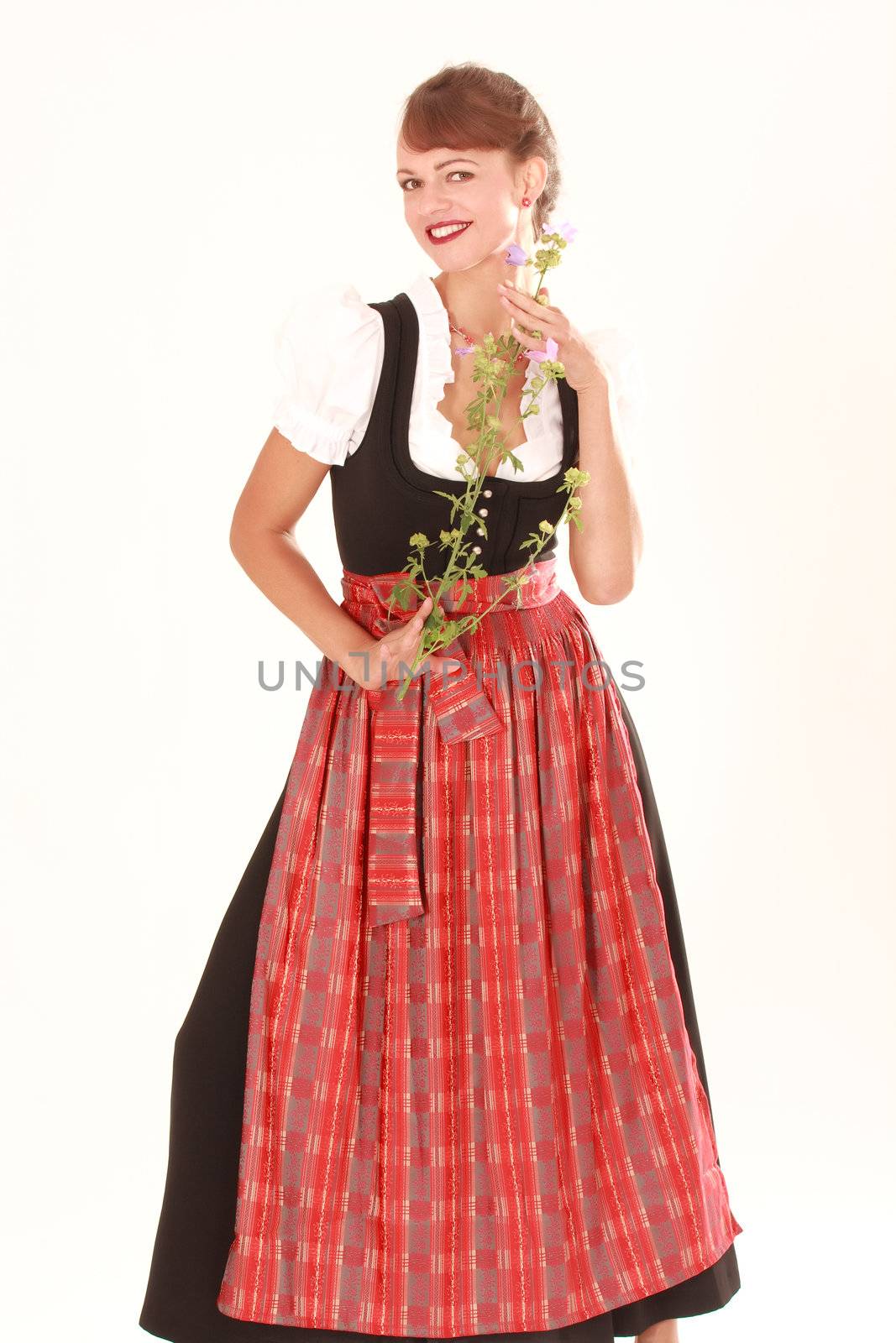 Bavarian woman in traditional dress posing with fragrant flower