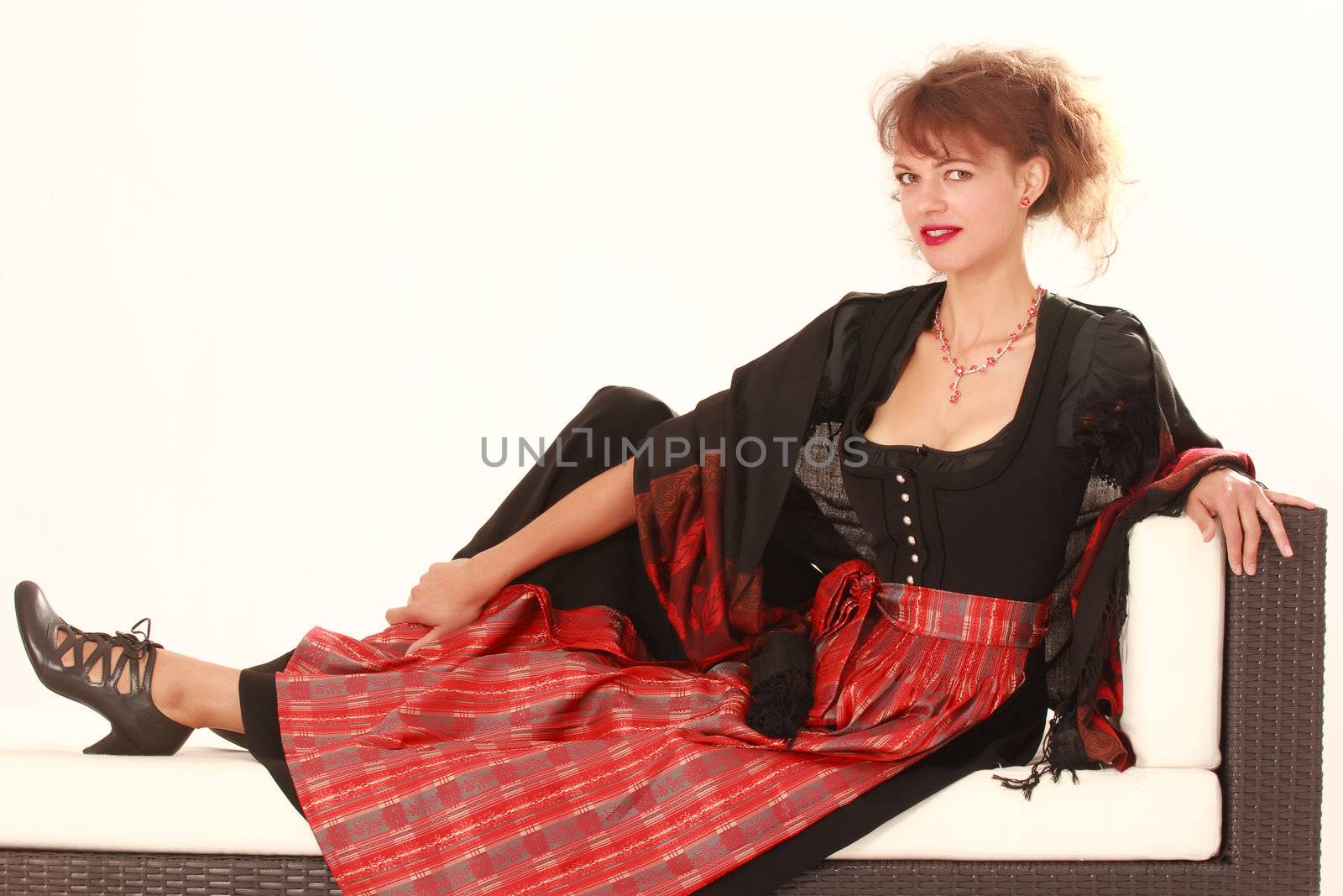 Bavarian woman in traditional dress on a sofa at rest