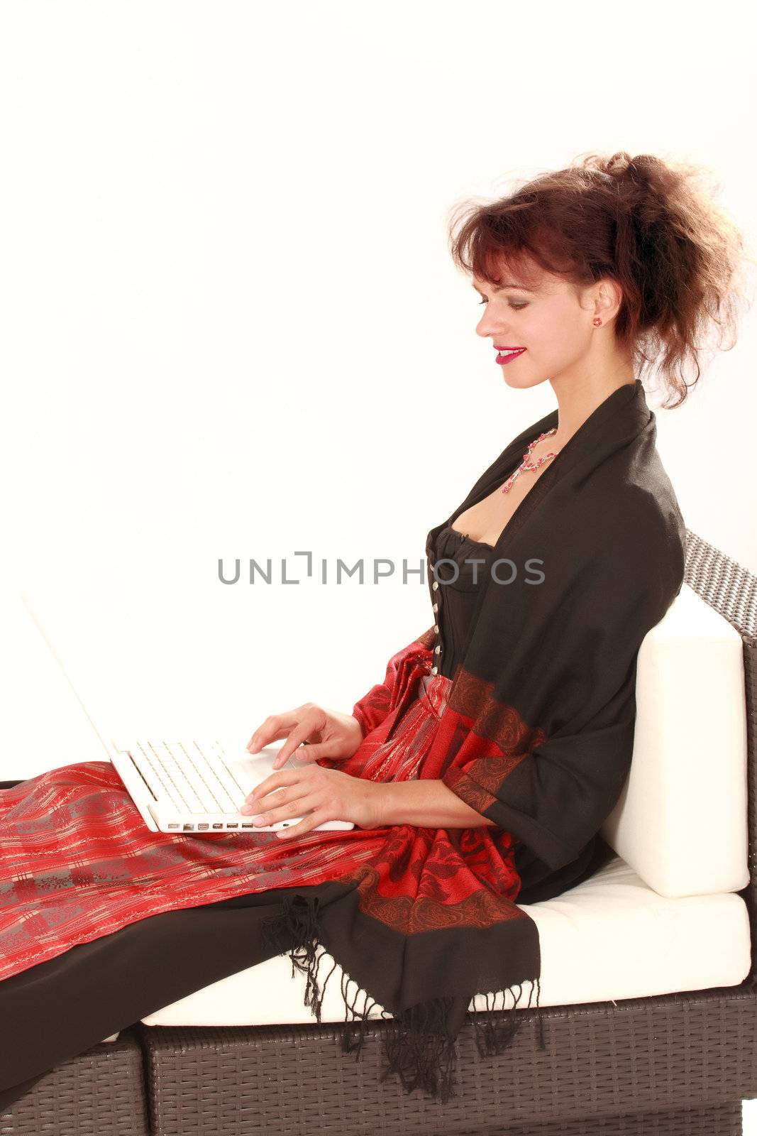 Bavarian girl costume with laptop on sofa