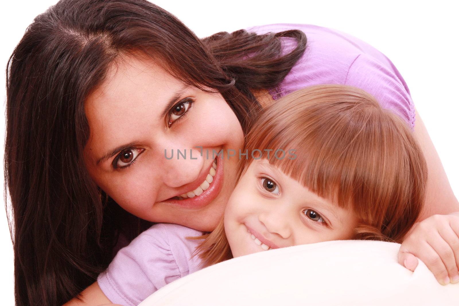 Mother and daughter posing happily in bed