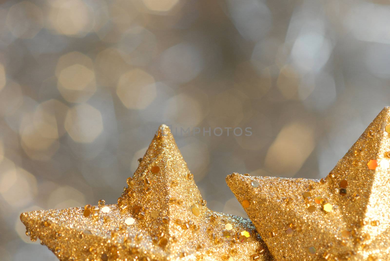 Christmas background with two gold stars blurred foreground