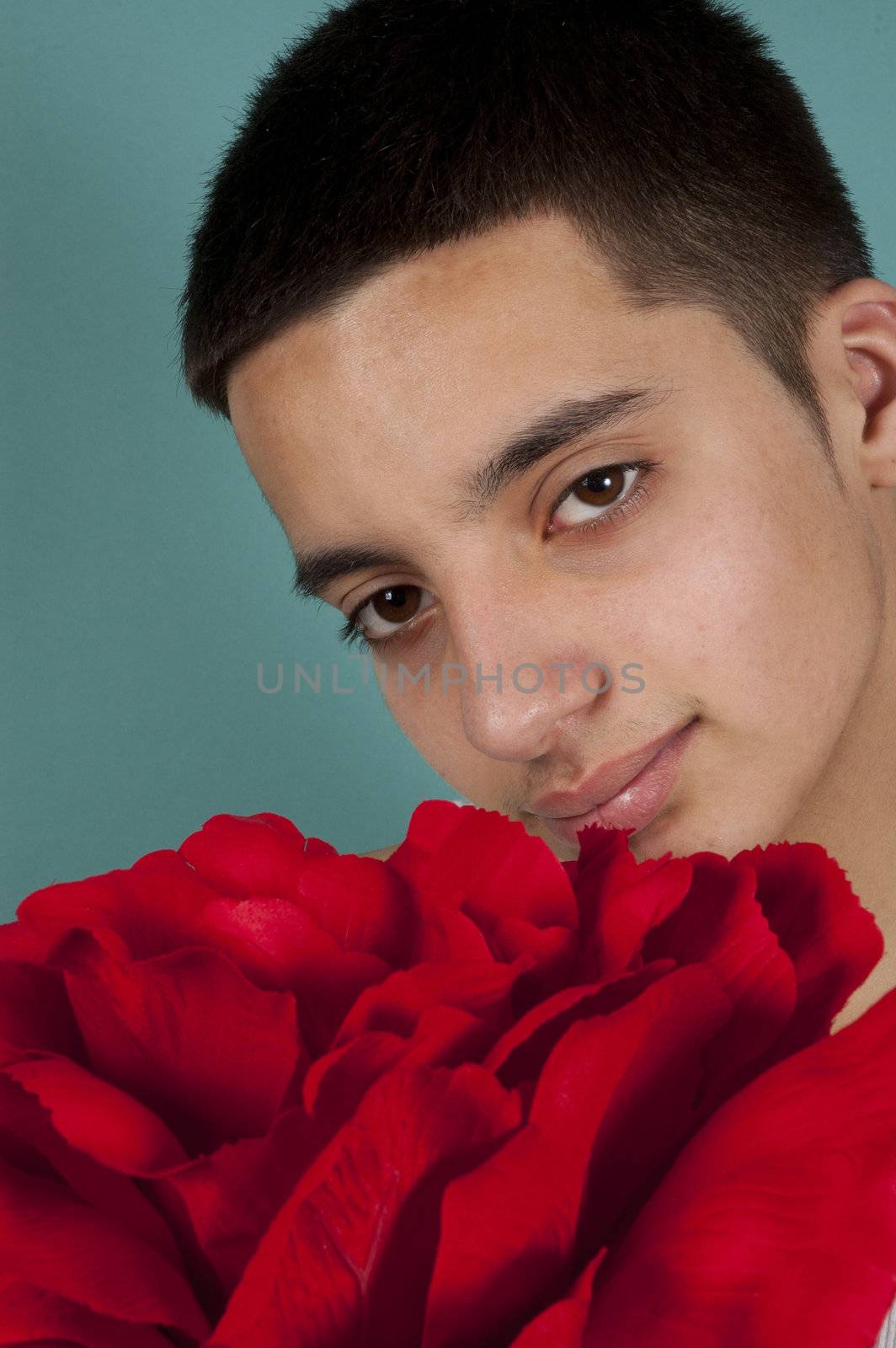 teenage pakistani boy holding a big red rose;