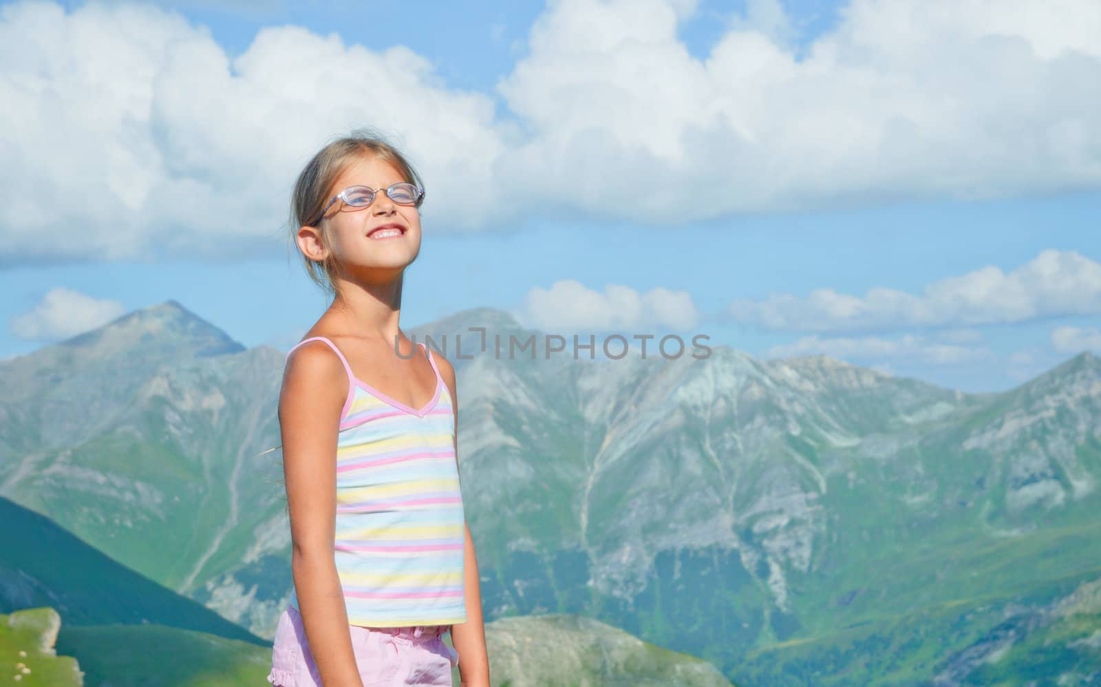 girl hiker standing on a rock and looking at the mountains