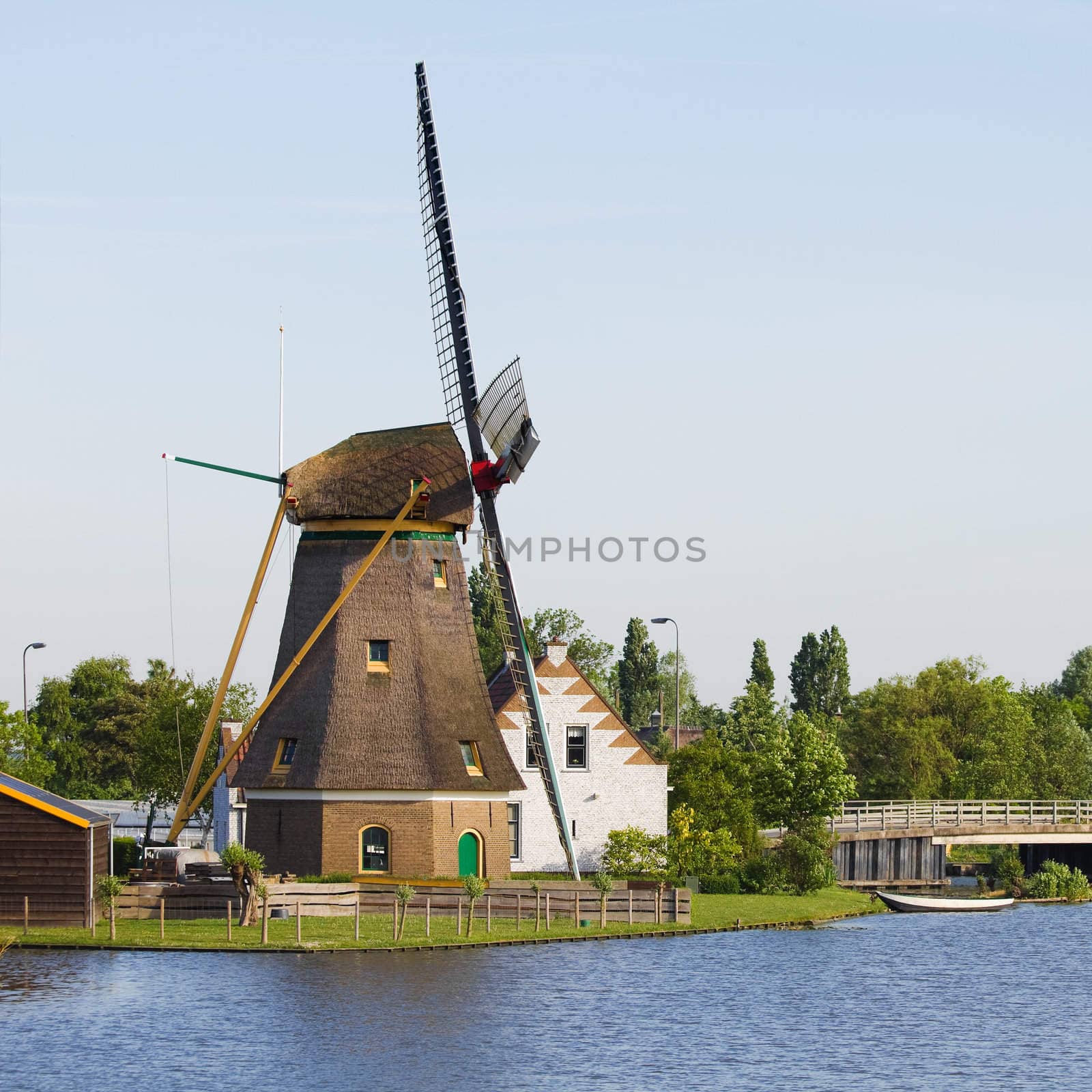 Dutch windmill, house and bridge at the waterside - square