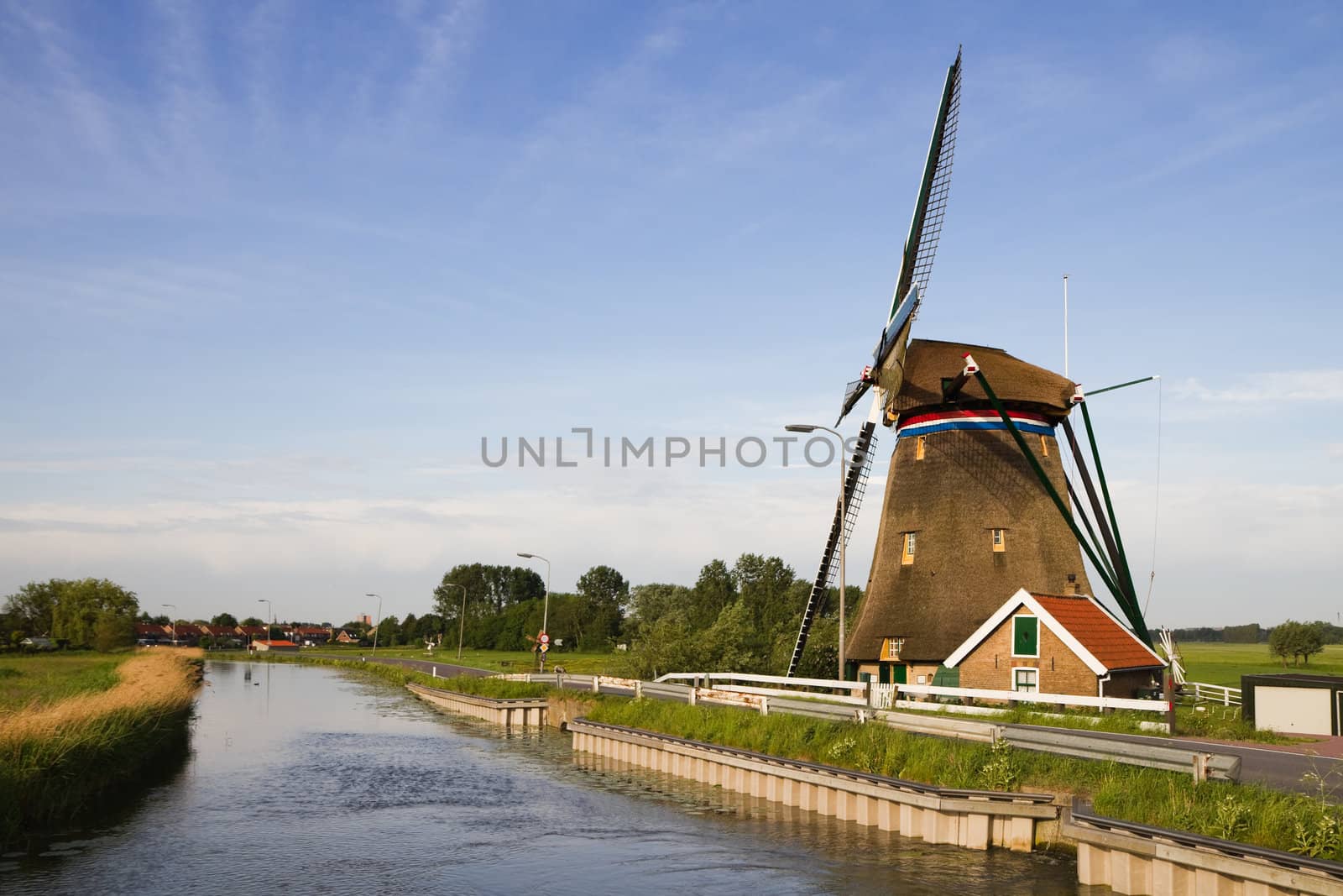 Dutch windmill and country road on beautiful morning 