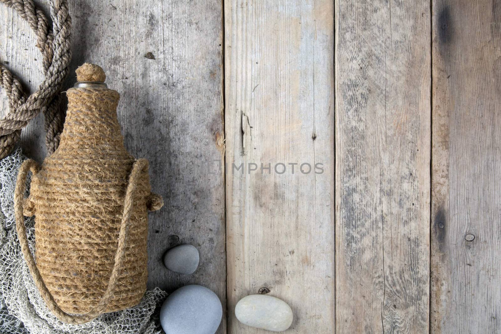 Bottle covered by tar rope with wooden background