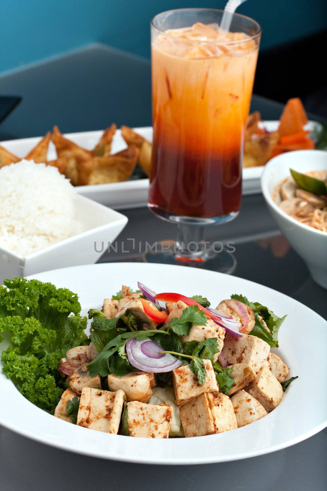 A nice assortment of Thai food and appetizers presented beautifully with fancy garnish with copy space.