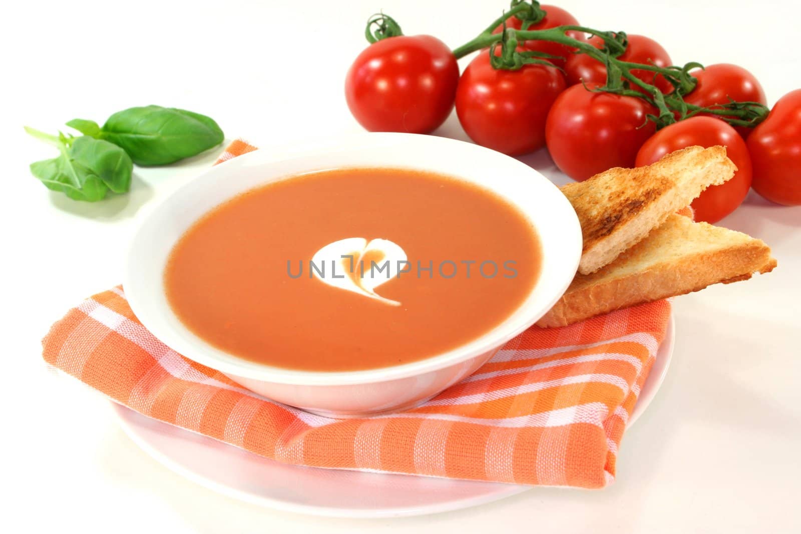 a bowl of tomato cream soup with toast
