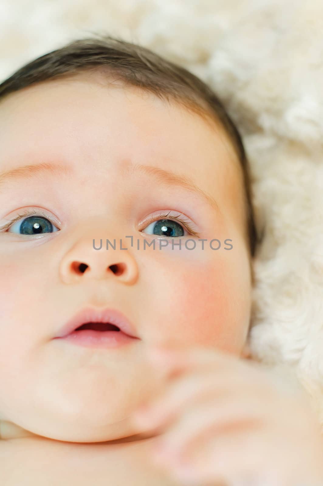 Beautiful cute baby boy is lying in a bed. Vertical view