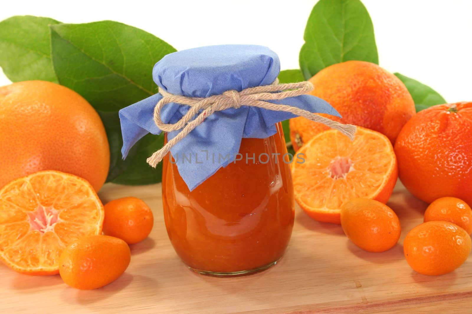 Orange marmalade with different Citrus fruits on a wooden board