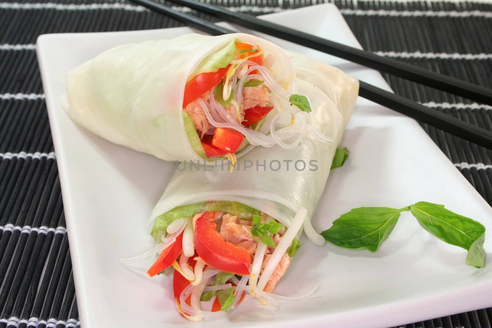 Lucky roll with lettuce, salmon, rice noodles, bell peppers and Thai basil