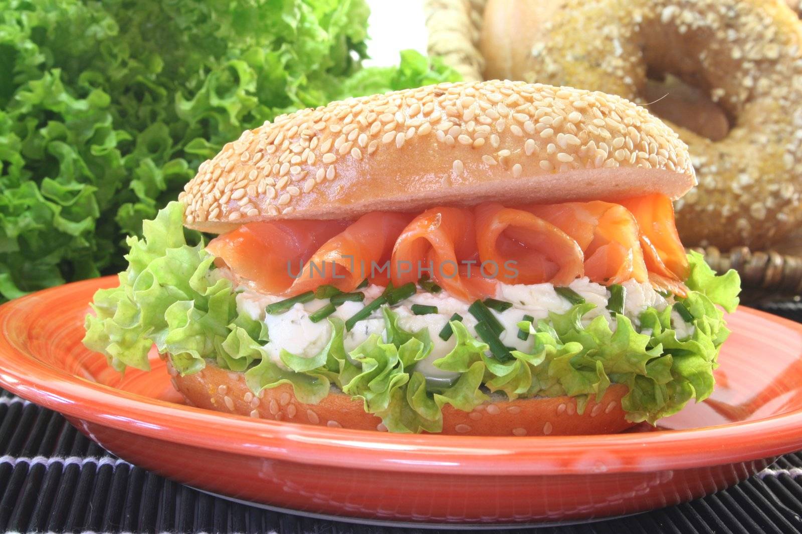 Sesame bagel with lettuce, cream cheese and salmon