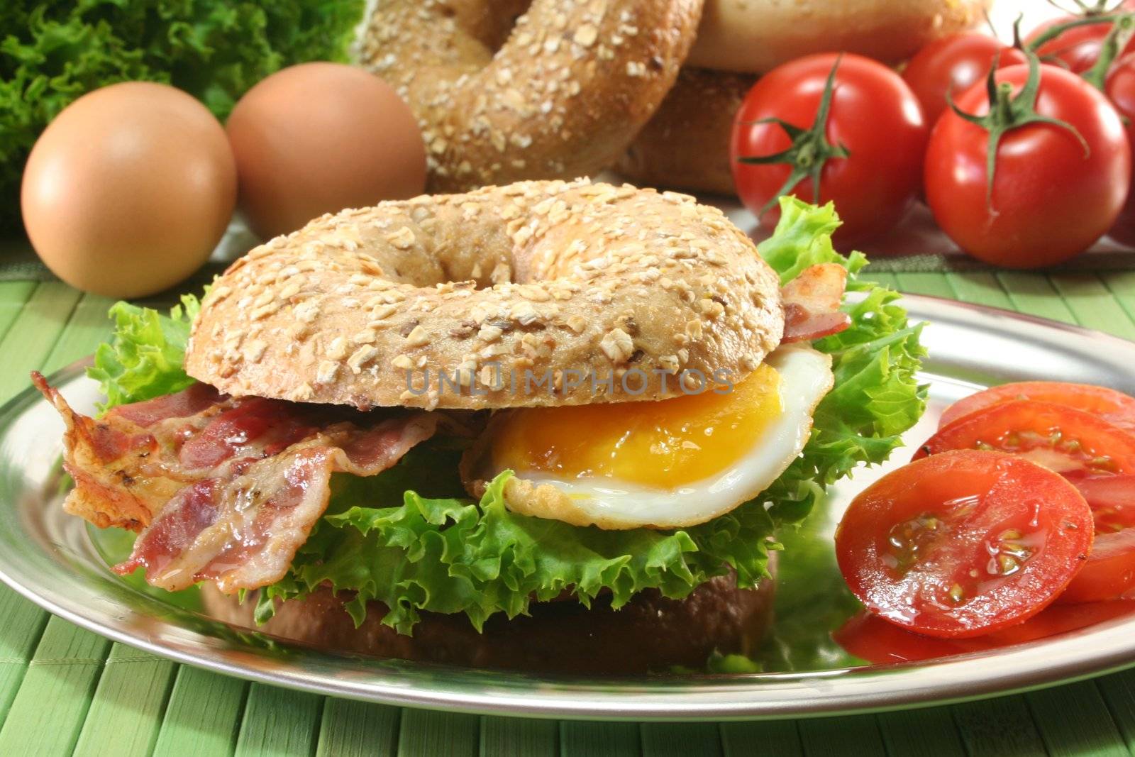 Rye bagel with salad, fried egg and bacon