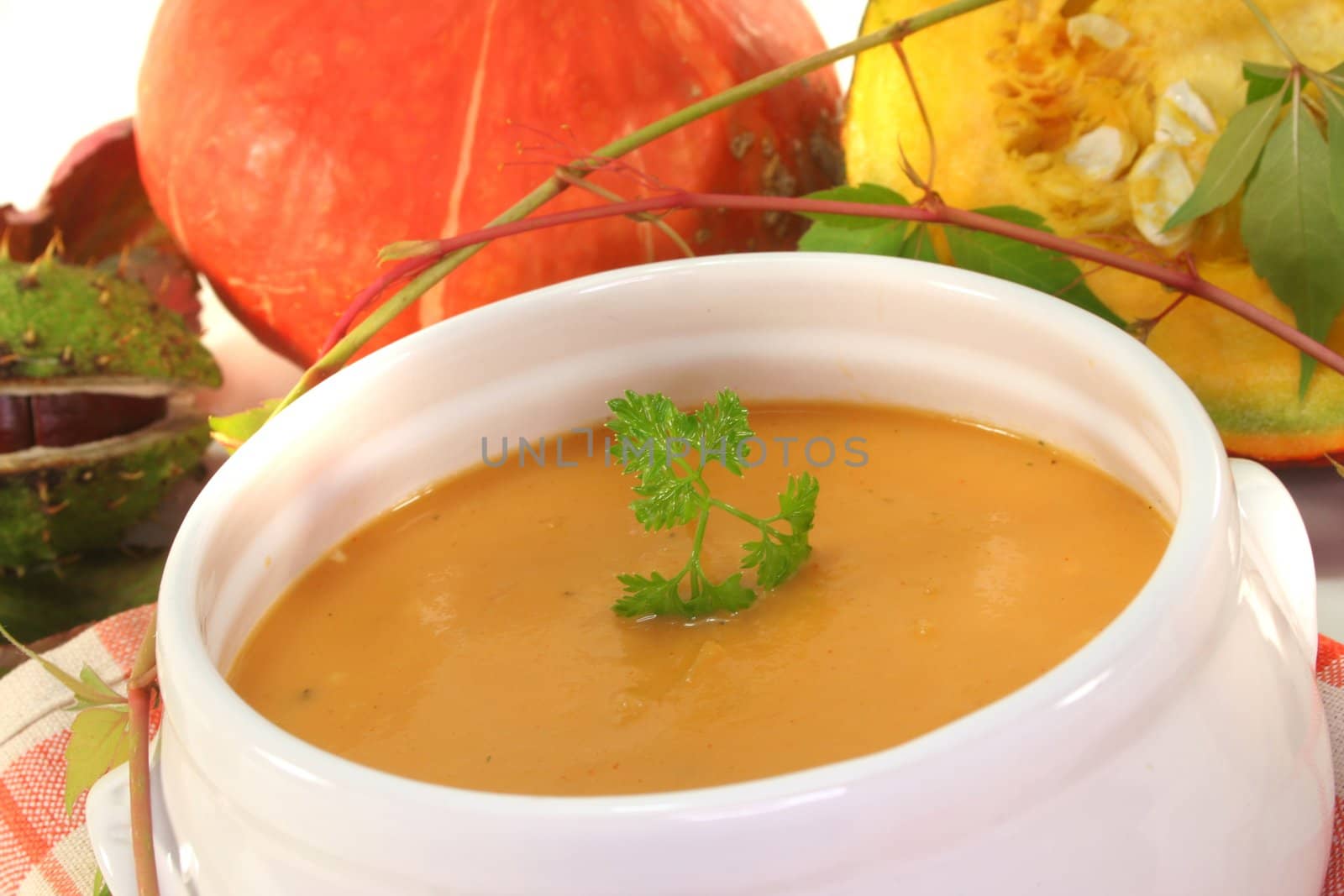 Pumpkin cream soup with fresh Hokkaido pumpkin and autumn leaves