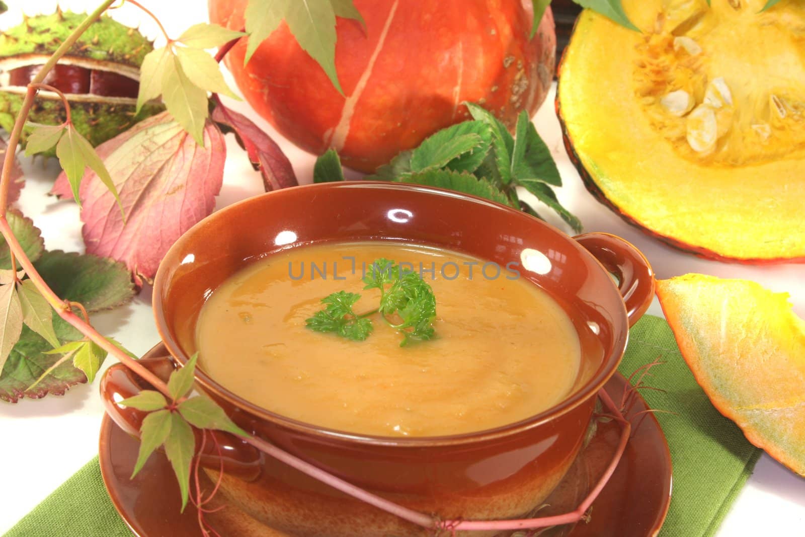 Pumpkin cream soup with fresh Hokkaido pumpkin and autumn leaves