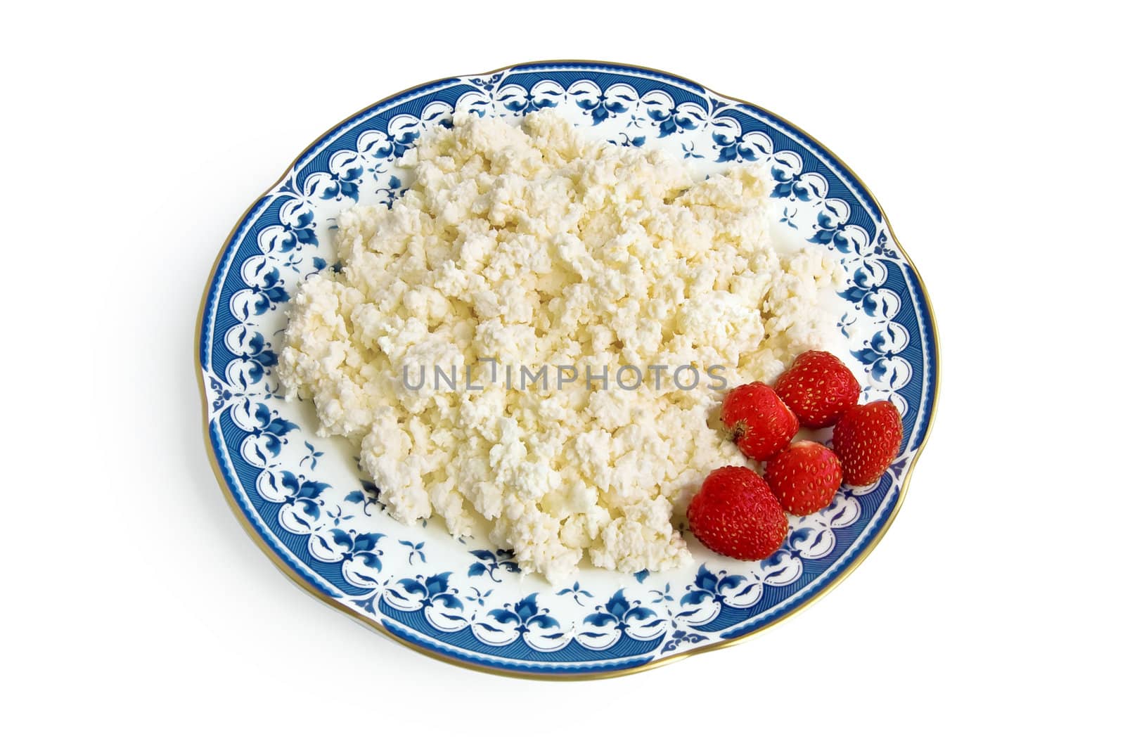 Cottage cheese with berries red ripe strawberries on the plate with a blue ornament is isolated on a white background