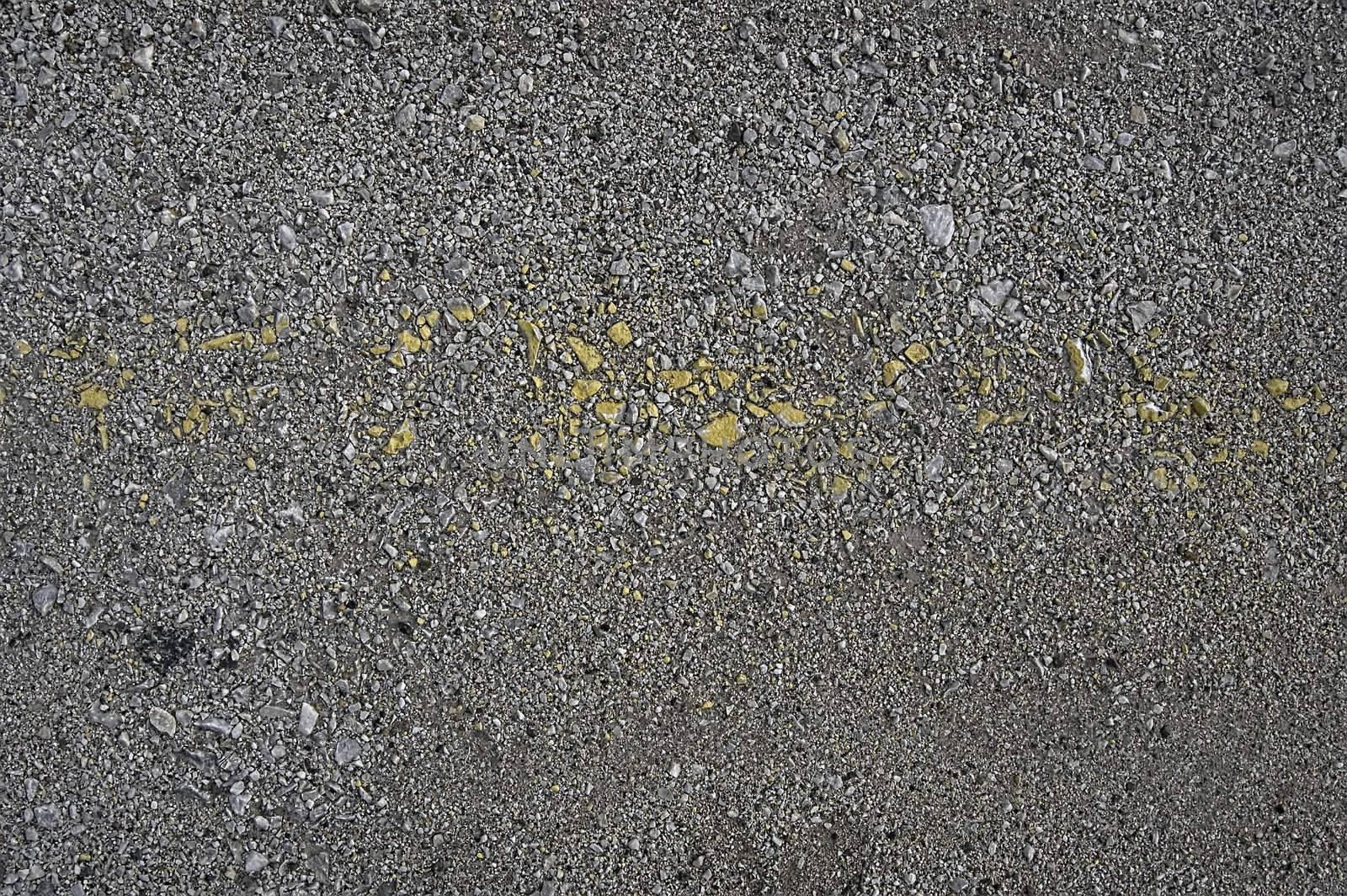 Gray gravel with a strip of yellow paint (texture)