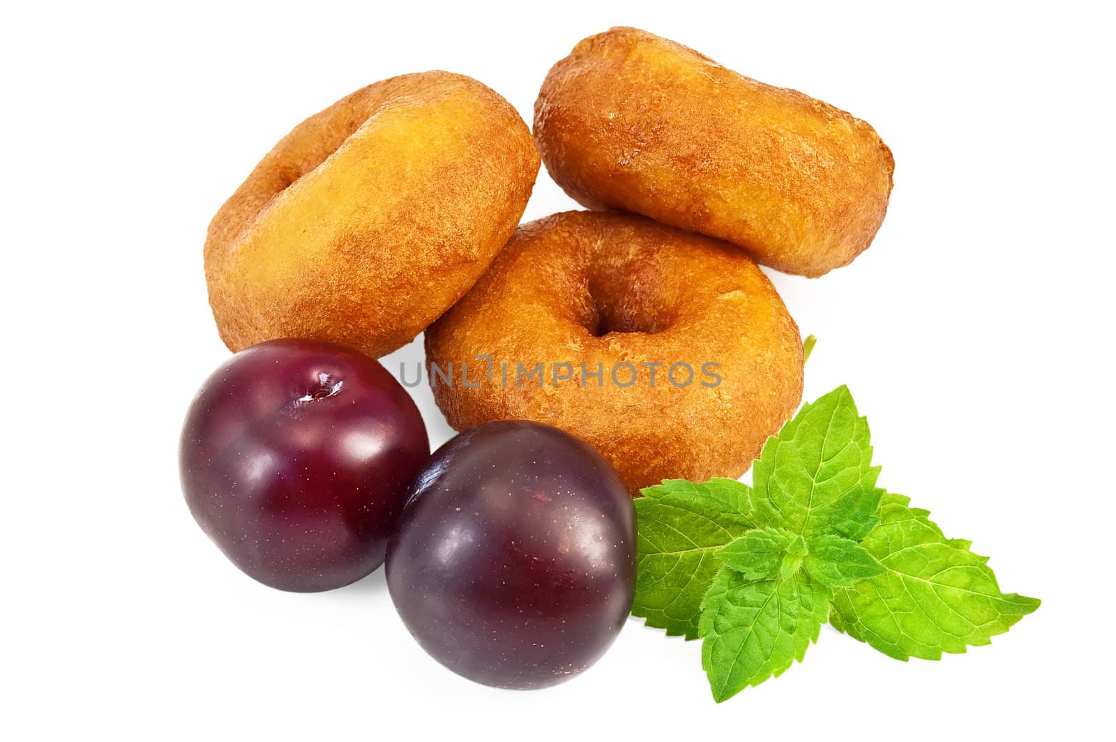 Three donuts, sprig of green mint, two plums isolated on a white background