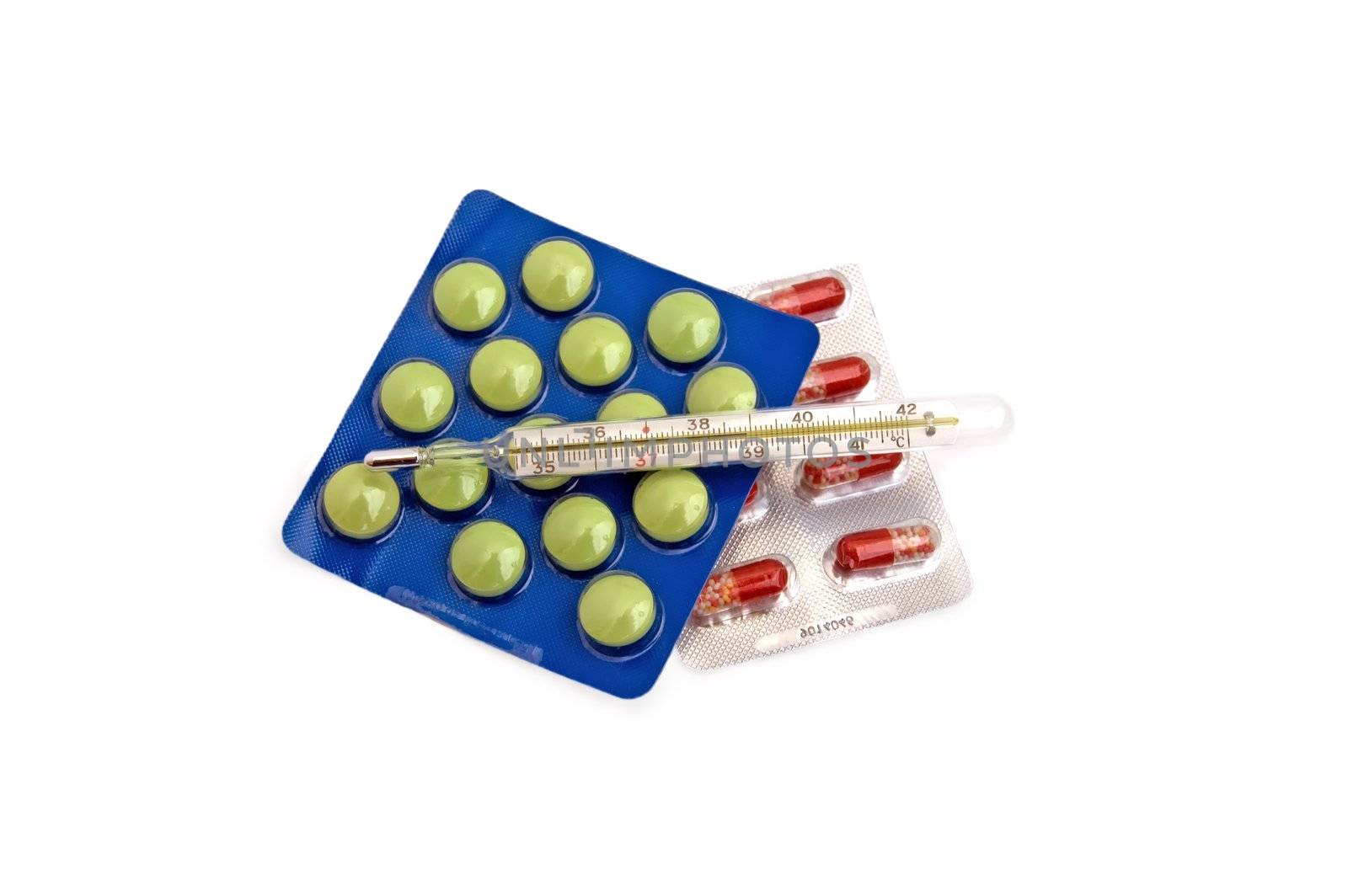 Thermometer with multi-colored pills and capsules in the package on a white background