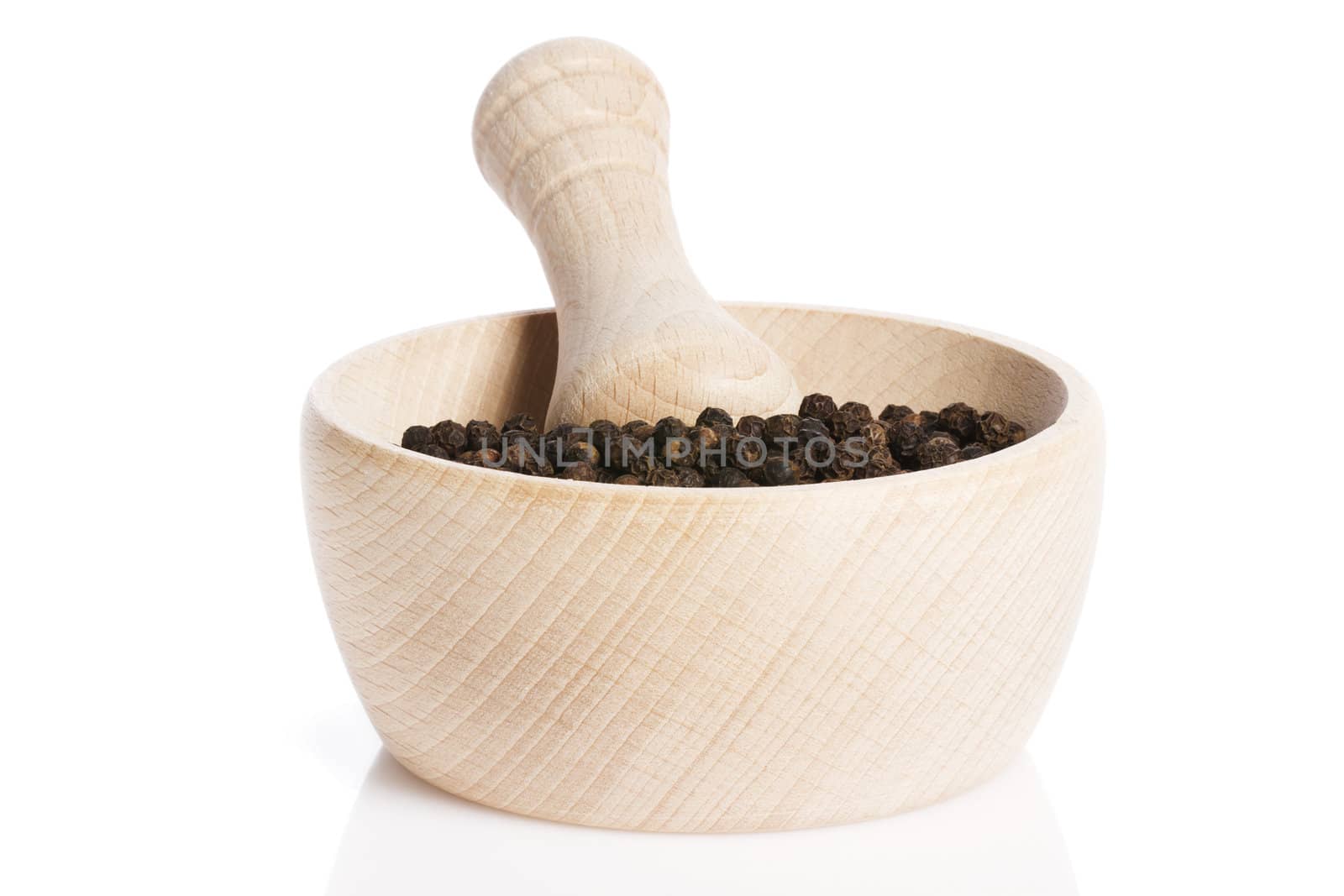 peppercorns in a wooden mortar on white background