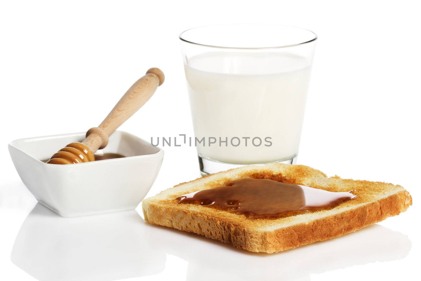 toast with honey, a glass of milk and a honey dipper in a jar with honey on white background