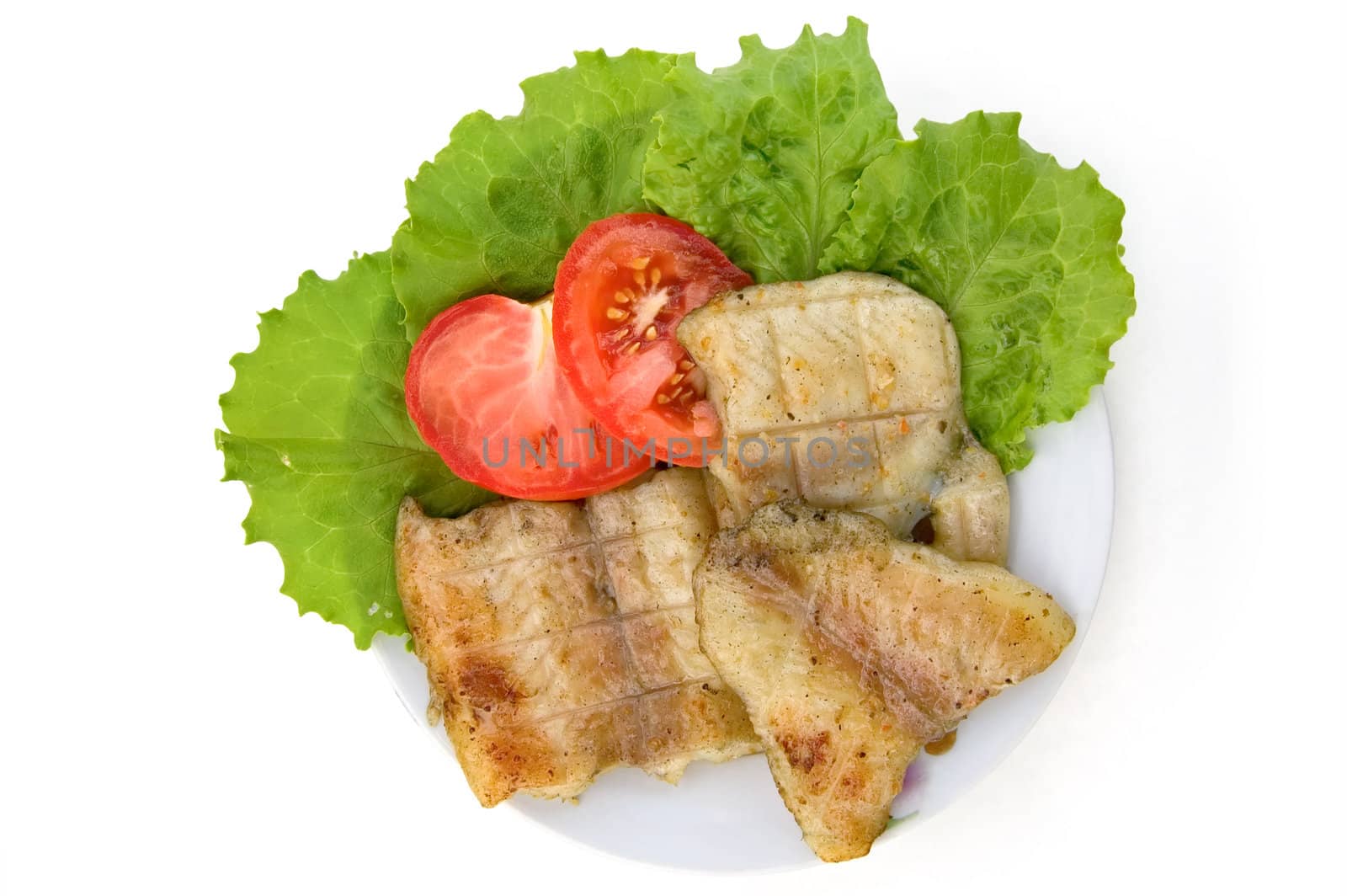 Fish grilled, two slices of red tomatoes, lettuce on a plate isolated on a white background