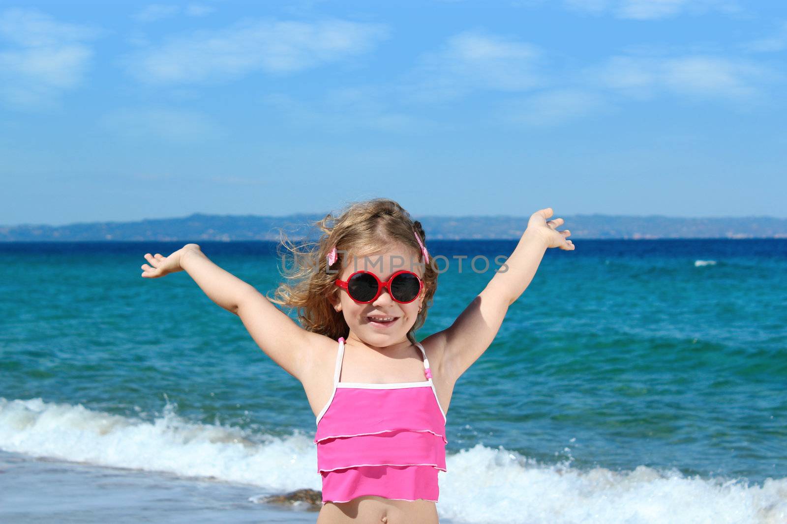 happy little girl with sunglasses on the beach by goce