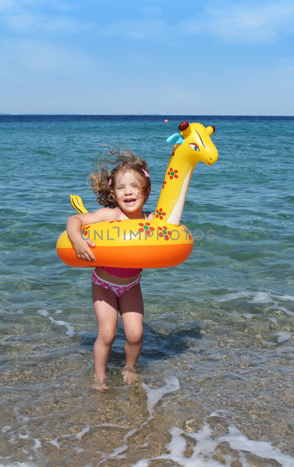 happy little girl jumps in the sea by goce