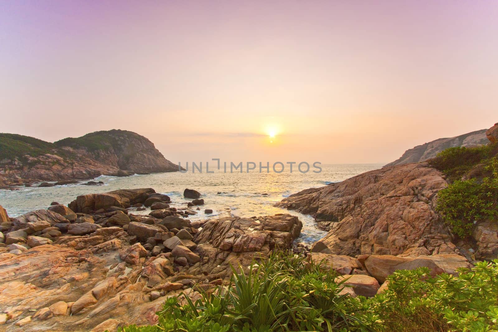Sea rocks along the coast under sunrise by kawing921